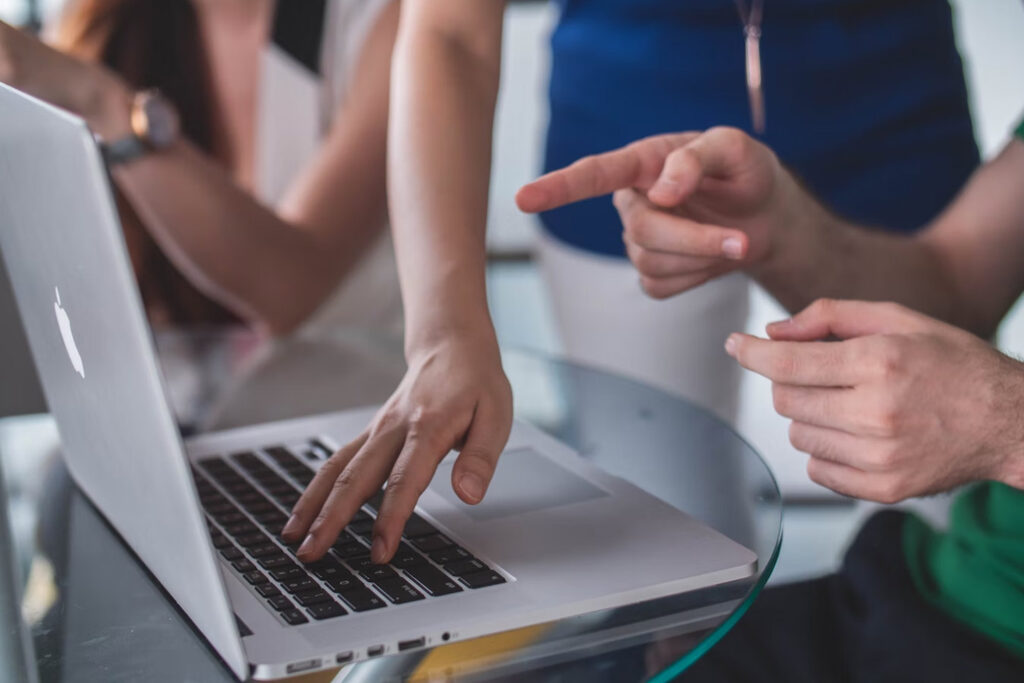 Two people's hands and a laptop