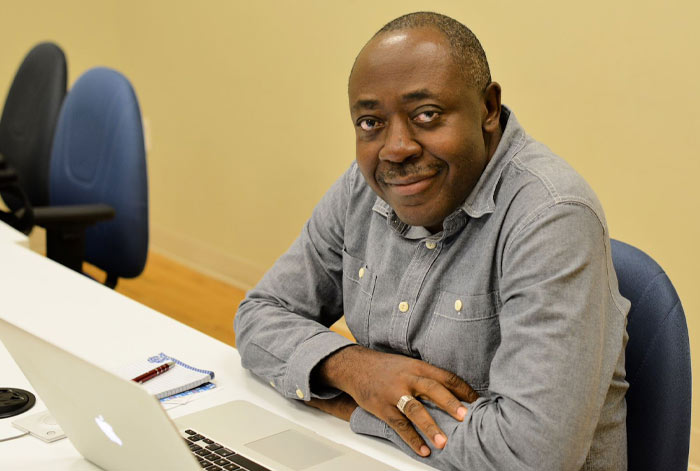 Adult student smiling at the camera in front of a laptop