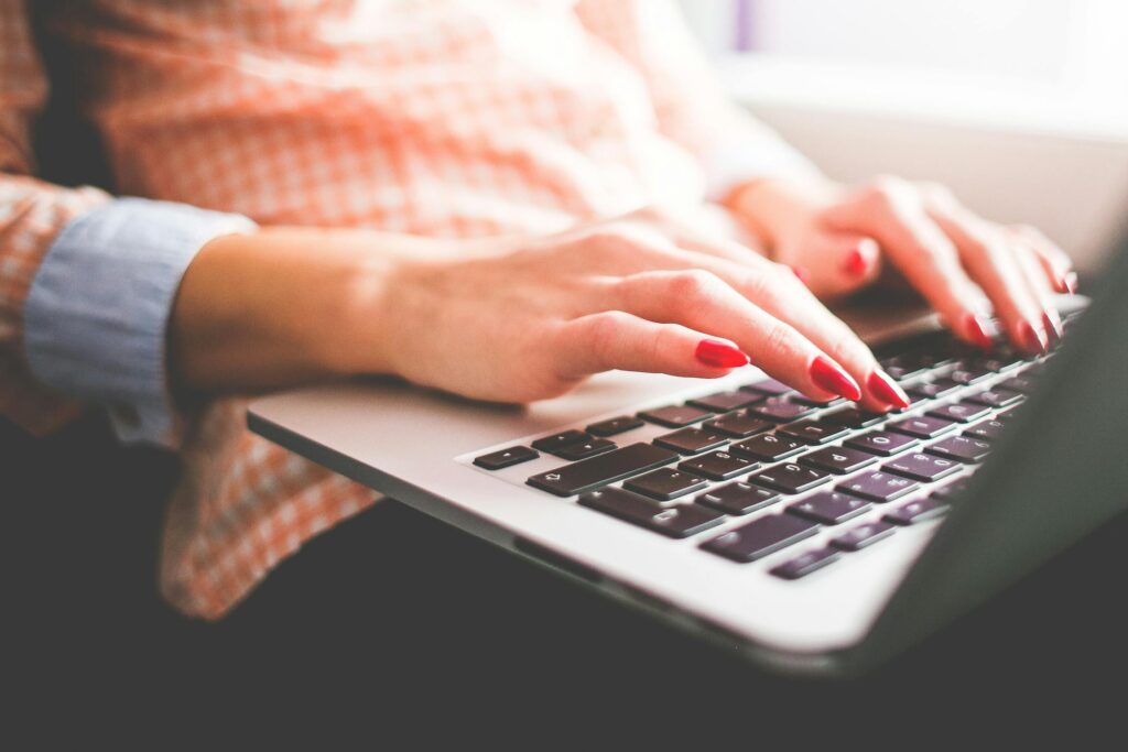 Hands typing on laptop